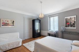 a bedroom with a bed and a couch and a chair at B&B L'Annexe De Camillac in Bourg-sur-Gironde