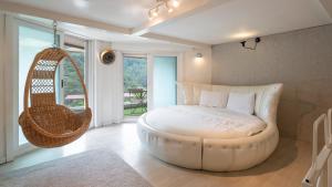 a room with a large white bed and a swing at Gapyeong Solle Spa Pension in Gapyeong