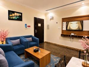 a living room with blue couches and a table at توارن للشقق المخدومة - الاقتصادية in Riyadh