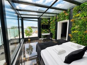 ein Schlafzimmer mit Bett und ein Balkon mit Pflanzen in der Unterkunft Hotel Lantier - Basen & Gabinet SPA in Bytom