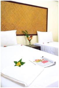 2 camas en una habitación de hotel con mando a distancia en Koh Mook Rubber Tree Bungalows en Ko Mook