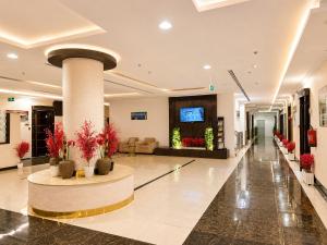 a lobby of a hotel with a column and flowers at توارن للشقق المخدومة - الاقتصادية in Riyadh