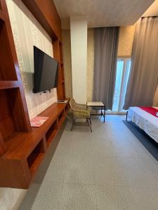 a hotel room with a television and a bed at Regency Sunset Condotel in Angeles