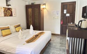 a hotel room with a bed with towels on it at Sunday Rainforest Chiangmai Hotel in Chiang Mai