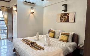 a bedroom with a large bed with towels on it at Sunday Rainforest Chiangmai Hotel in Chiang Mai +80 photos