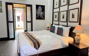 a bedroom with a large bed with white sheets and pillows at Sunday Rainforest Chiangmai Hotel in Chiang Mai