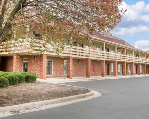 a red brick building with a tree in front of it at Quality Inn Findlay in Findlay