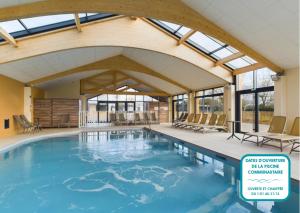 a large indoor pool with chairs and windows at Chalet moderne pour 6 - proximité des plages in Saint-Gilles-Croix-de-Vie