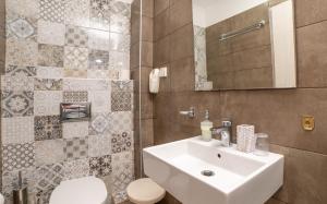a bathroom with a white sink and a toilet at Achilleas Hotel in Parga