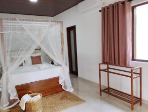 a bedroom with a bed with mosquito net at The White Porch in Kurunegala