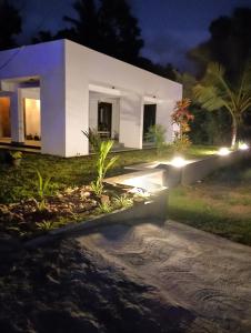 a white house with lights in front of it at The White Porch in Kurunegala