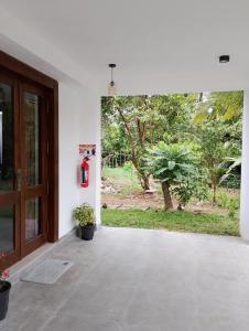 an empty room with a door and a garden at The White Porch in Kurunegala