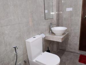 a bathroom with a white toilet and a sink at The White Porch in Kurunegala