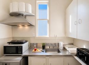 a kitchen with a sink and a microwave at CitiRooms Auckland in Auckland +18 photos
