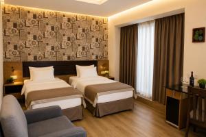 a hotel room with two beds and a couch at Hotel Gareji Kakheti in Sagarejo