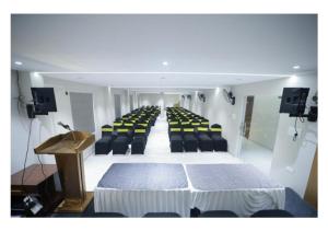 a conference room with chairs and a table and a podium at Kanak Residency Kuthuparamba in Kottayam