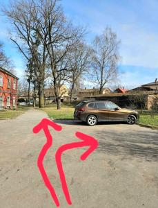a car parked in a parking lot with two red arrows at Muna Living in Riga