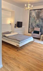 a bedroom with a bed and a couch and a chair at Muna Living in Riga
