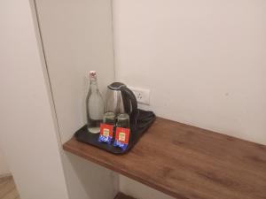 a shelf with a bottle and two bottles on it at IVAA RESoRT from kodai lake in Kodaikānāl