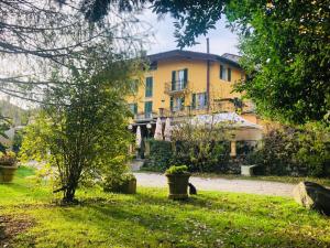 a yellow house in the middle of a yard at Villa Coppa Hotel in Dazio