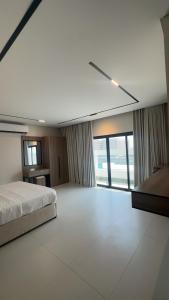 a large bedroom with a bed and a large window at Dara in Al Khobar