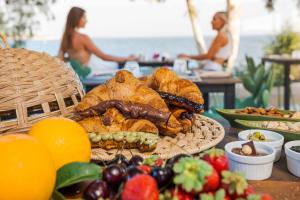 a table topped with a basket of pastries and fruit at Zurafa Resort in Terrauzza