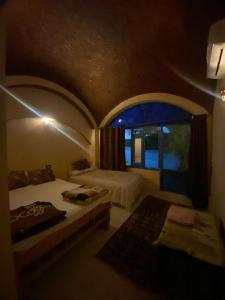 a small bedroom with two beds and a window at Hooly Nubian in Aswan
