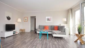a living room with a couch and a table at Strandhaus Lobbe, App 04 - Bade- & Saunawelt täglich inklusive in Lobbe