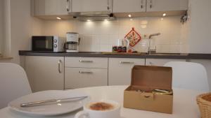 a kitchen with a table with a cup of coffee on it at Strandhaus Lobbe, App 04 - Bade- & Saunawelt täglich inklusive in Lobbe