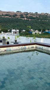 a pool of water with a view of a city at The Seven Suites - Fort View in Chittaurgarh