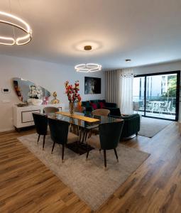 a dining room and living room with a table and chairs at Visconde II F in Ribeira Brava