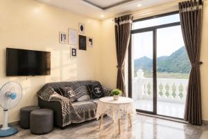 a living room with a couch and a tv at Cat Ba Sky Home in Cat Ba