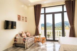 a bedroom with a bed and a couch and a window at Cat Ba Sky Home in Cat Ba