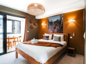 a bedroom with a large bed and a table at L'Escale Bleue in Saint-Leu