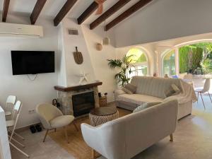 a living room with a couch and a fireplace at Casa Palmerita a 7 minutos andando de una playa de aguas cristalinas in Teulada