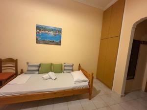 a bedroom with a bed with a painting on the wall at Irene's Sunny apartment in Limnos in Néa Koútali