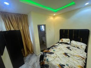a bedroom with a bed with a green ceiling at Etsuko hotel and suites world city in Atan
