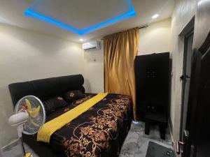 a bedroom with a bed and a blue light at Etsuko hotel and suites world city in Atan