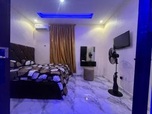 a bedroom with a bed and a television in it at Etsuko hotel and suites world city in Atan
