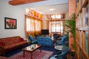 uma sala de estar com sofás e cadeiras e uma televisão em Hotel Bettina em Lido di Jesolo