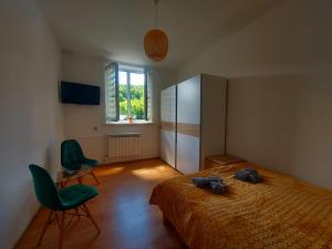 a bedroom with a bed and two chairs and a window at Ustrzycki Zakątek in Ustrzyki Dolne