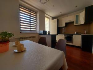 a kitchen with a white table and chairs and a table at Ustrzycki Zakątek in Ustrzyki Dolne +9 photos