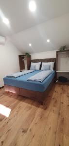 a large bed in a room with a wooden floor at Apartman Terasa in Bijeljina