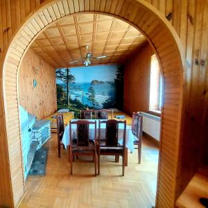 a dining room with a table and chairs and an archway at Ustrzycki Zakątek in Ustrzyki Dolne