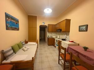 a kitchen with a table and chairs and a room with a kitchen at Irene's Sunny apartment in Limnos in Néa Koútali