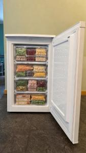 an open refrigerator filled with lots of fruits and vegetables at Le Petit Château de Harzé - Spa de nage chauffé toute l'année in Aywaille