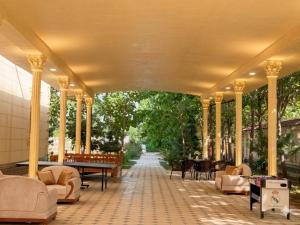 a covered porch with couches and tables and chairs at GREEN APPLE GUEST House in Tashkent