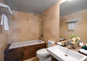 a bathroom with a tub and a toilet and a sink at Faifo Boutique Hotel & Spa in Thanh Ðông (1)
