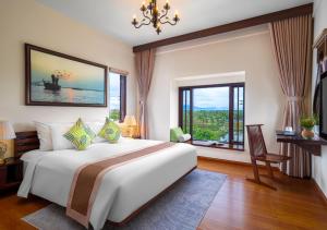 a bedroom with a large bed and a large window at Faifo Boutique Hotel & Spa in Thanh Ðông (1)