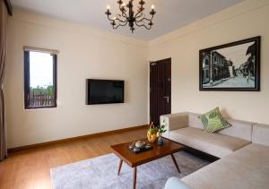 a living room with a couch and a tv at Faifo Boutique Hotel & Spa in Thanh Ðông (1)